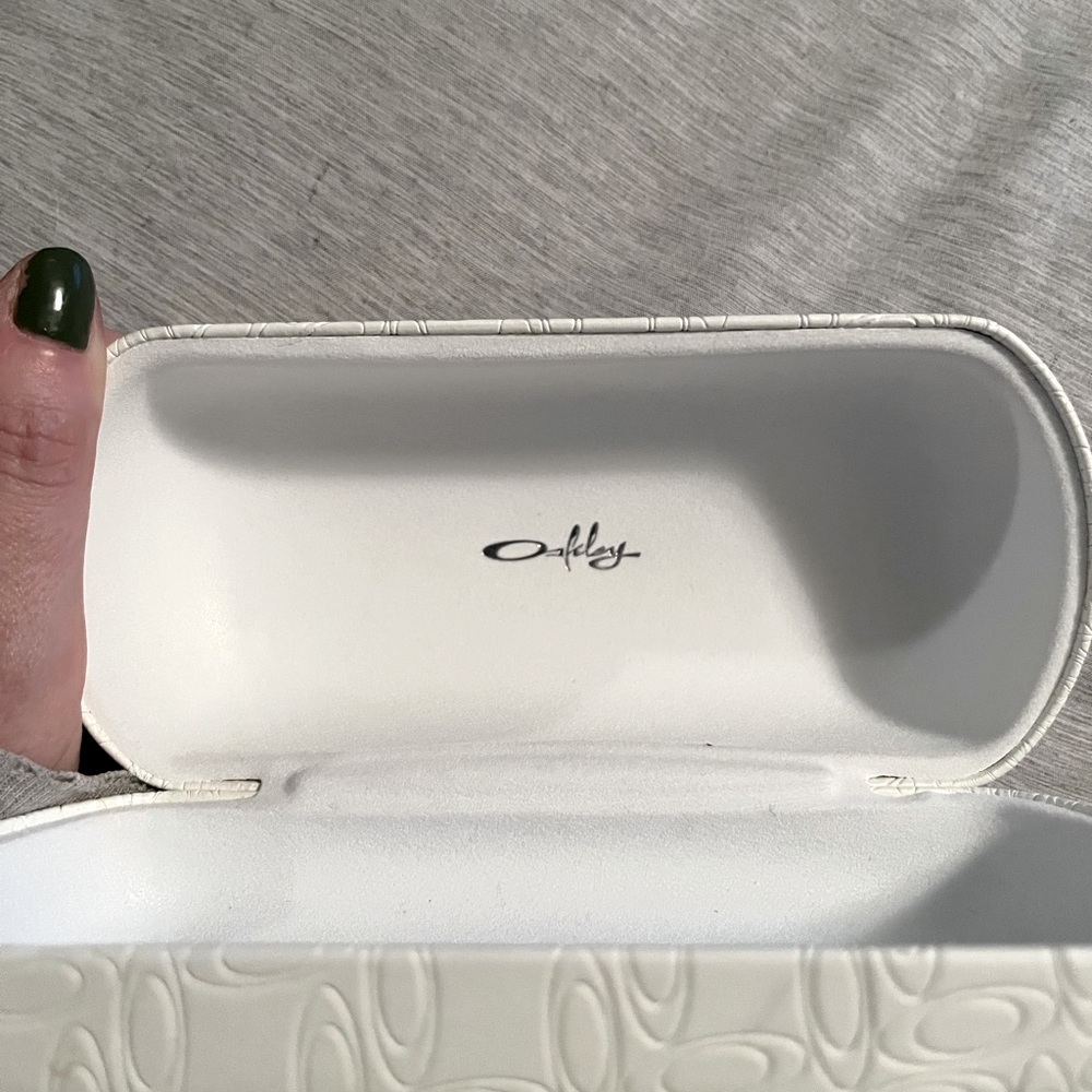 Oakley sun glass case with never used cleaning cloth and spray.